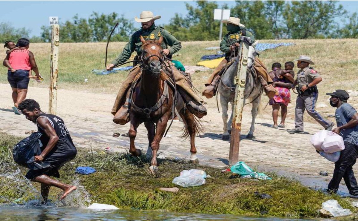 Agentes migratorios montados en caballo persiguiendo a migrantes haitianos