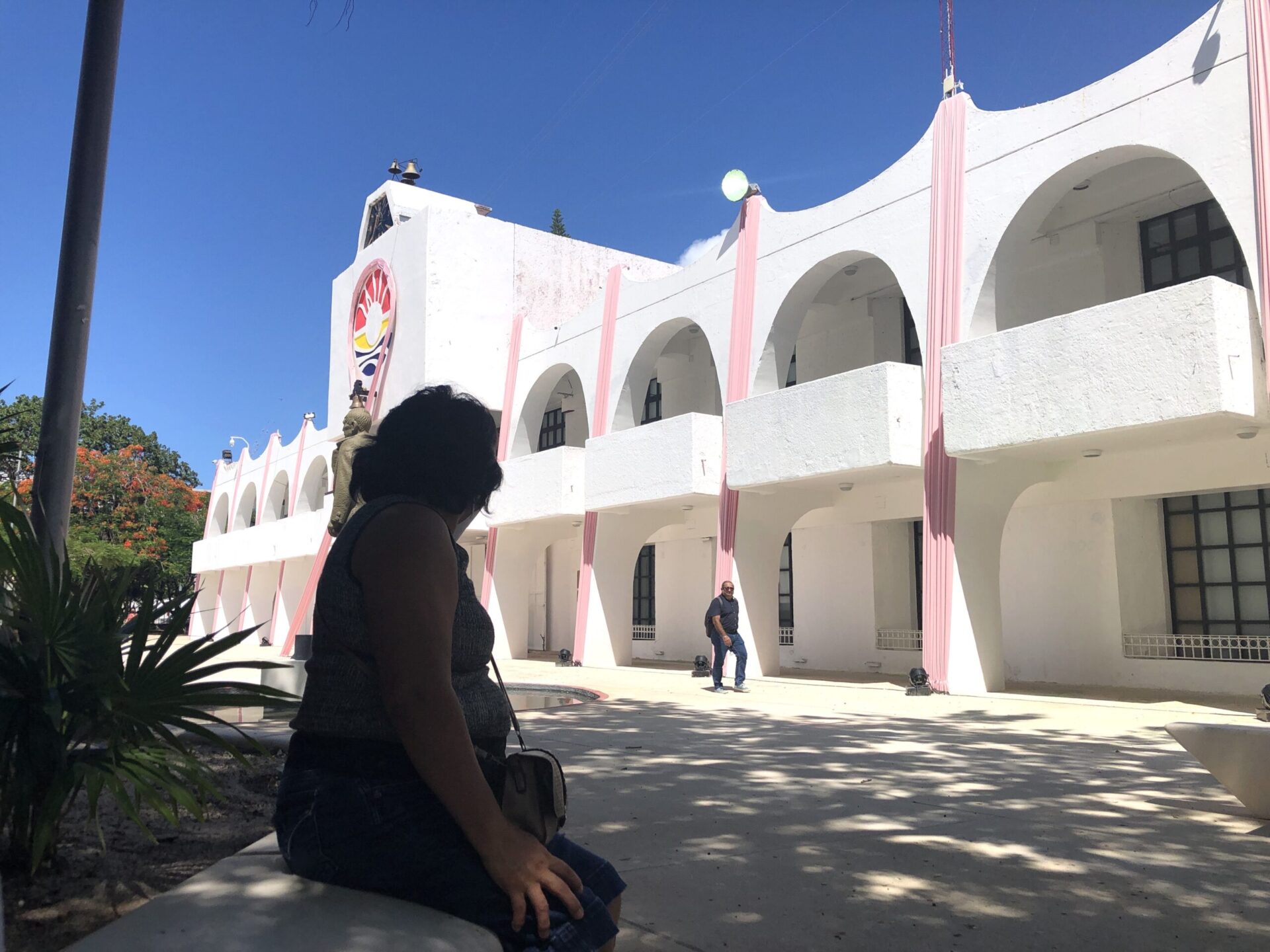 Señoara sentada frente a palacio municipal